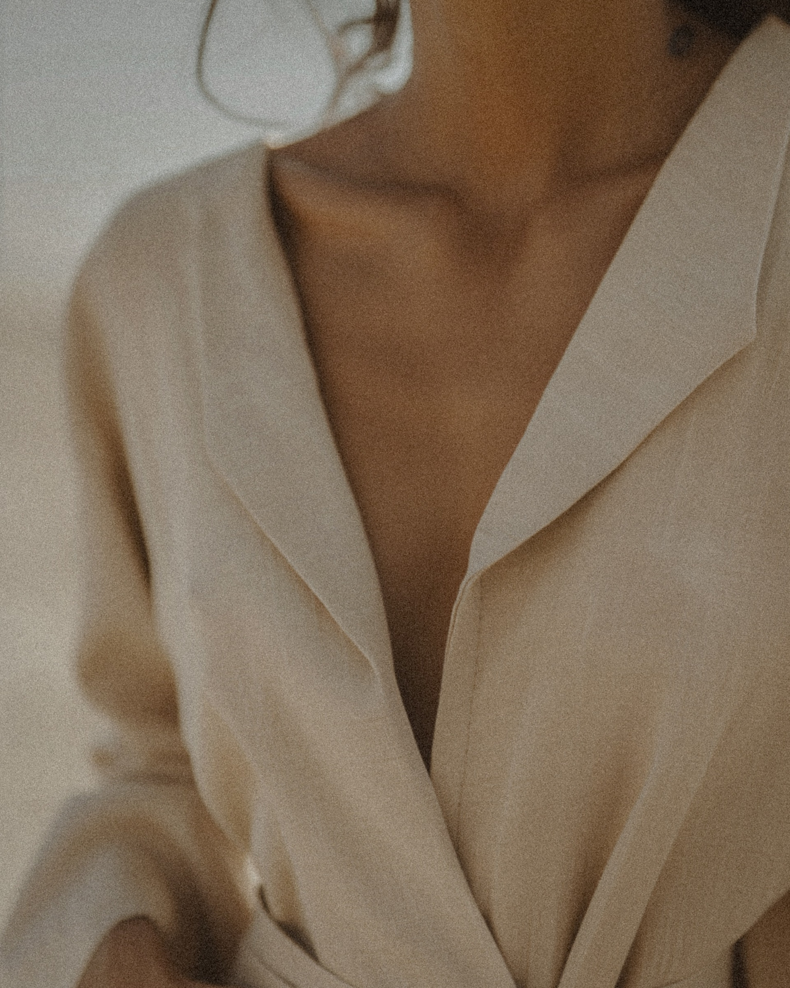 A soft beige blazer worn over bare skin